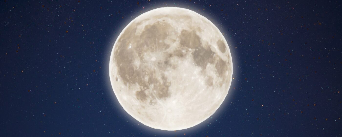 Iridescent glow of full moon in the night starry sky